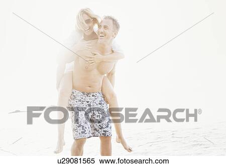 Man carrying girlfriend on beach View Large Photo Image Stock Photography - Man carrying girlfriend on beach. Fotosearch