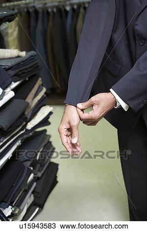 Stock Image - Man fitting business suit in shop. Fotosearch