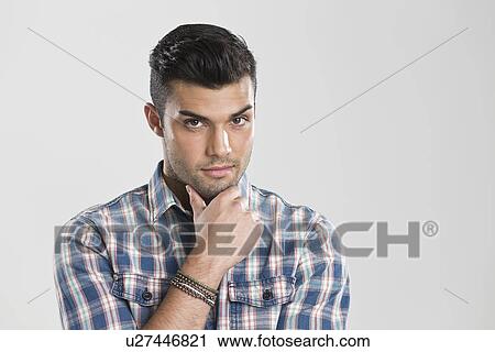 Stock Image - Man holding chin in hands. Fotosearch