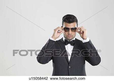 Man in tuxedo adjusting his sunglasses View Large Photo Image Stock Image - Man in tuxedo adjusting his sunglasses. Fotosearch