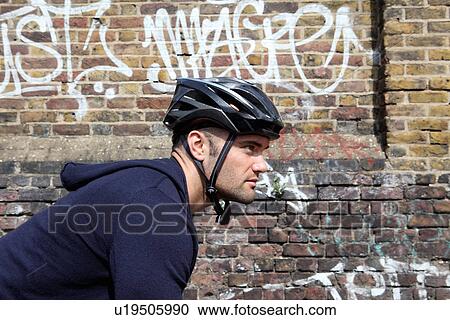 Man riding bicycle on city street View Large Photo Image Stock Image - Man riding bicycle on city street. Fotosearch