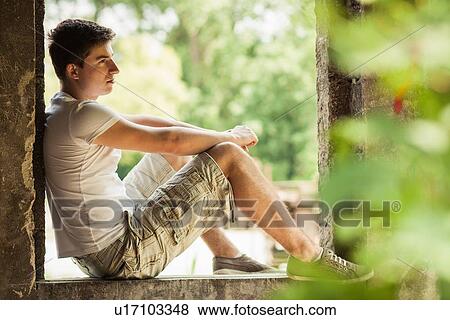 Man sitting in windowsill View Large Photo Image Stock Photo - Man sitting in windowsill. Fotosearch