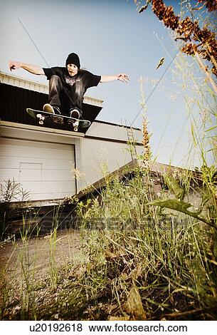 Man skating on grassy concrete View Large Photo Image Stock Photo - Man skating on grassy concrete. Fotosearch