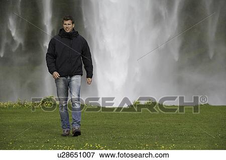 Stock Photo - Man walking in grassy field. Fotosearch
