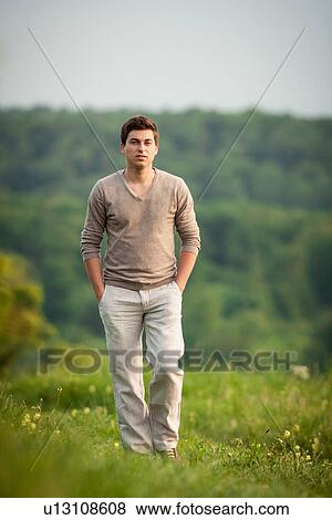 Stock Photo - Man walking on grass hillside. Fotosearch