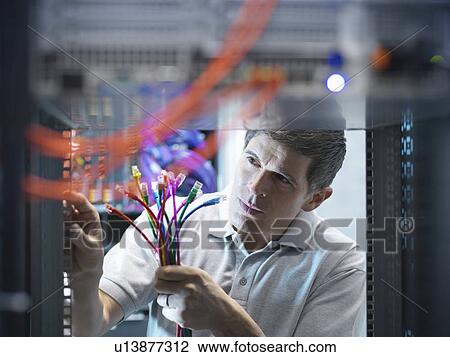 Stock Image - Man working in server room. Fotosearch
