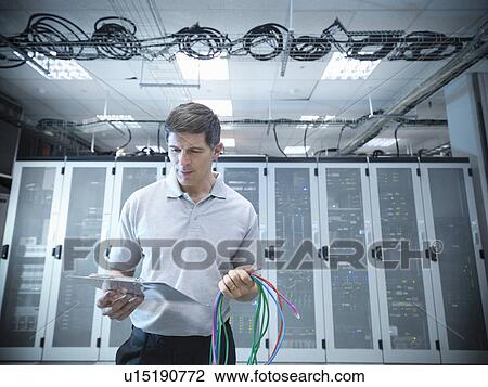 Stock Image - Man working in server room. Fotosearch