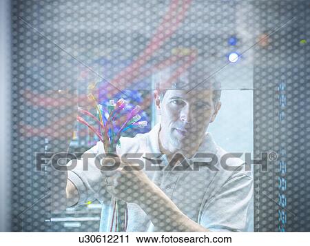 Stock Image - Man working in server room. Fotosearch