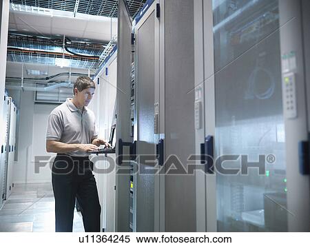 Stock Photography - Man working in server room. Fotosearch