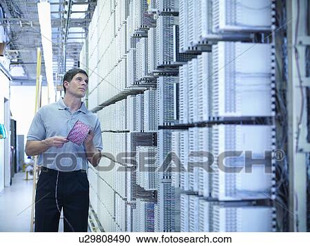 Stock Image - Man working in telephone exchange. Fotosearch