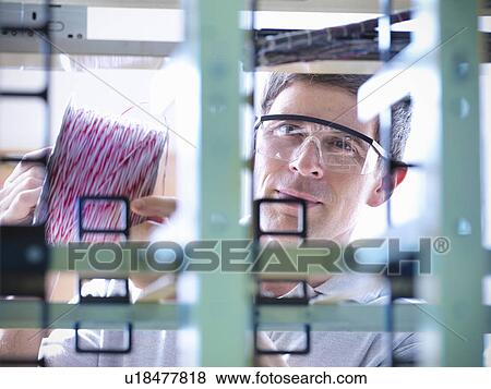 Stock Photo - Man working in telephone exchange. Fotosearch