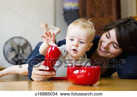 Picture - Mother and baby playing on floor. Fotosearch