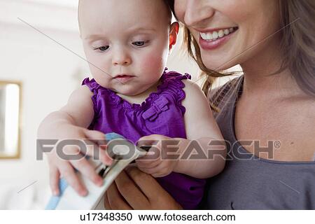 Mother and baby playing with tambourine View Large Photo Image Stock Image - Mother and baby playing with tambourine. Fotosearch