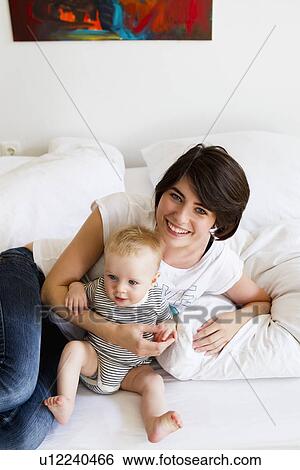 Mother and baby relaxing on couch View Large Photo Image Stock Photograph - Mother and baby relaxing on couch. Fotosearch