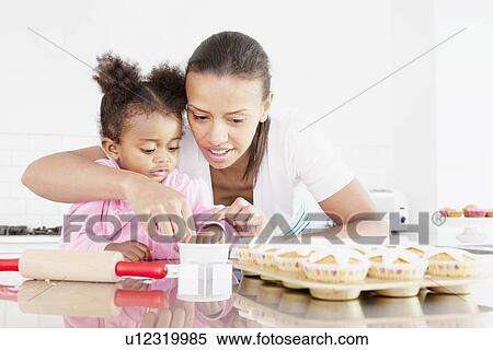 Mother and daughter baking together View Large Photo Image Stock Photography - Mother and daughter baking together. Fotosearch