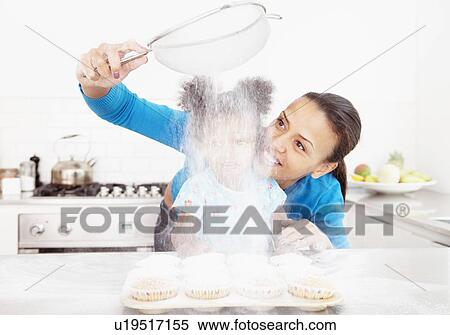Stock Photography - Mother and daughter baking together. Fotosearch