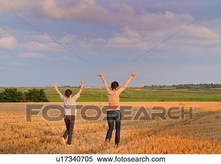 Mother and daughter cheering in field View Large Photo Image Stock Photography - Mother and daughter cheering in field. Fotosearch