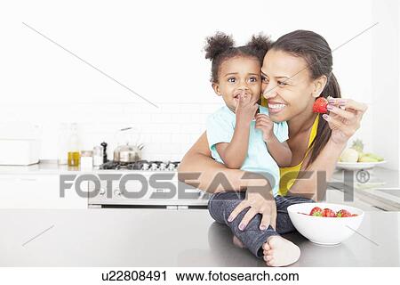Mother and daughter eating fruit View Large Photo Image Stock Image - Mother and daughter eating fruit. Fotosearch