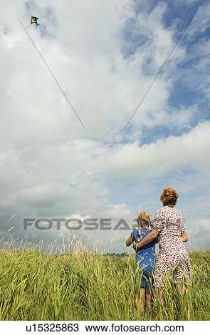 Mother and daughter flying kite in field View Large Photo Image Stock Image - Mother and daughter flying kite in field. Fotosearch