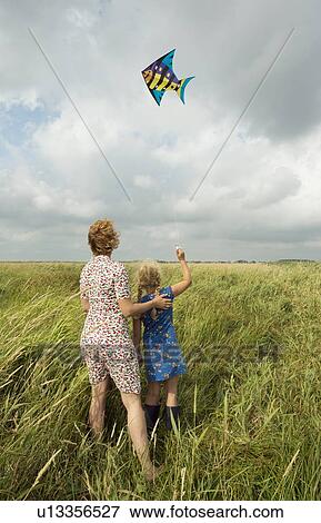 Mother and daughter flying kite in field View Large Photo Image Stock Photo - Mother and daughter flying kite in field. Fotosearch