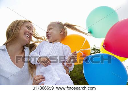 Stock Photo - Mother and daughter holding balloons. Fotosearch