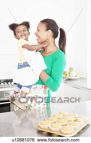 Mother and daughter laughing in kitchen View Large Photo Image Stock Photograph - Mother and daughter laughing in kitchen. Fotosearch