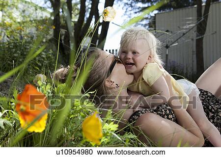 Stock Image - Mother and daughter playing outdoors. Fotosearch