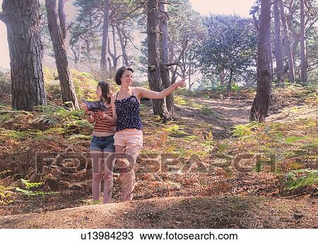 Stock Image - Mother and daughter reading forest map. Fotosearch