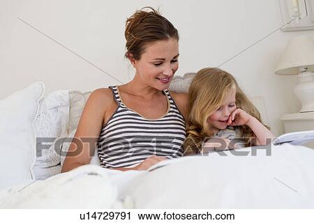 Mother and daughter reading in bed View Large Photo Image Stock Image - Mother and daughter reading in bed. Fotosearch