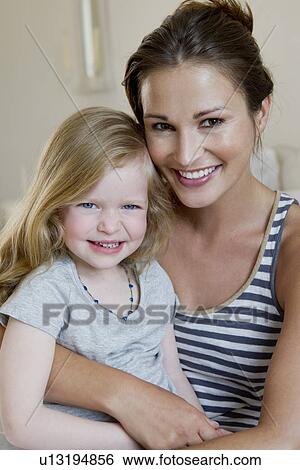 Stock Photograph - Mother and daughter smiling together. Fotosearch