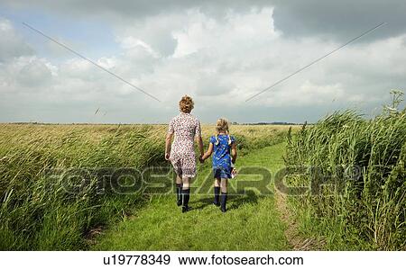 Stock Photo - Mother and daughter walking in field. Fotosearch