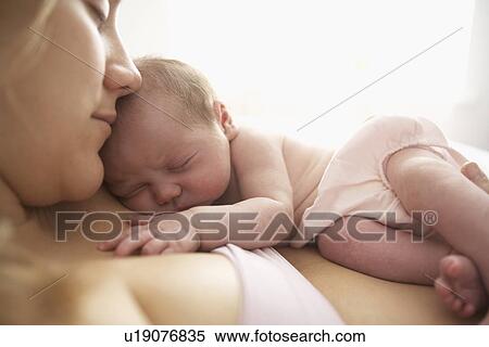 Stock Photography - Mother cradling newborn infant. Fotosearch