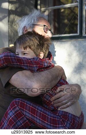 Stock Photography - Older man hugging grandson outdoors. Fotosearch