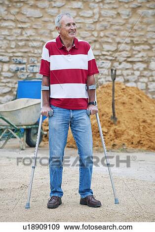 Older man standing with crutches View Large Photo Image Stock Photo - Older man standing with crutches. Fotosearch