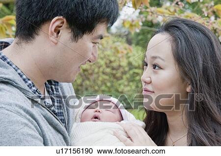 Parents holding sleeping baby outdoors View Large Photo Image Stock Image - Parents holding sleeping baby outdoors. Fotosearch