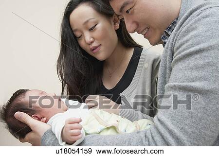 Stock Photo - Parents holding sleeping baby. Fotosearch