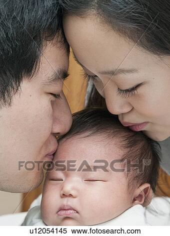 Parents kissing sleeping baby View Large Photo Image Stock Photography - Parents kissing sleeping baby. Fotosearch