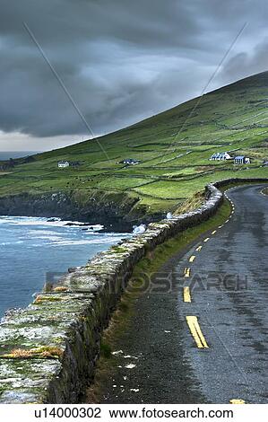 Stock Image - Paved road along rural cliffs. Fotosearch