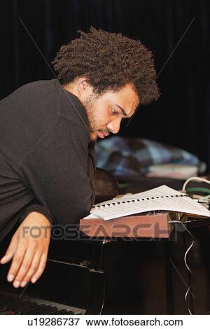 Stock Photo - Piano player reading sheet music. Fotosearch
