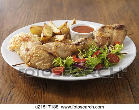 Stock Photo - Plate of chicken with salad and potatoes. Fotosearch