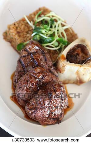 Stock Image - Plate of grilled beef with bone marrow. Fotosearch