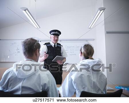 Stock Image - Policeman talking to forensic scientists. Fotosearch