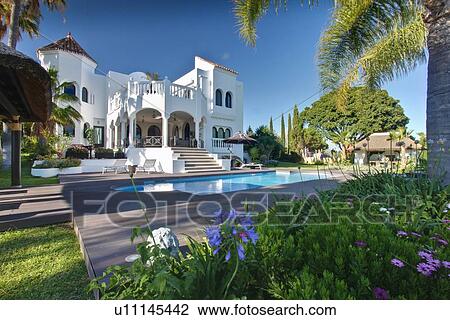 Stock Image - Pool outside tropical villa. Fotosearch