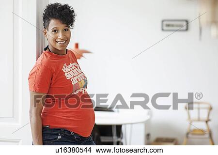 Pregnant woman leaning against doorway View Large Photo Image Picture - Pregnant woman leaning against doorway. Fotosearch