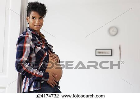 Pregnant woman leaning in doorway View Large Photo Image Stock Image - Pregnant woman leaning in doorway. Fotosearch