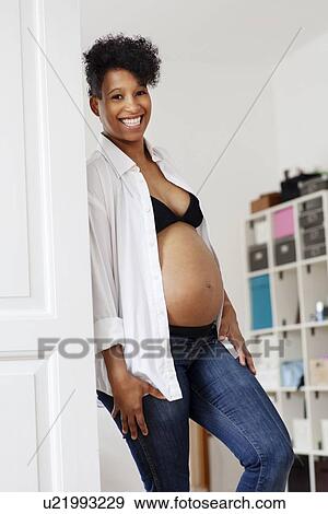 Stock Photo - Pregnant woman revealing belly. Fotosearch