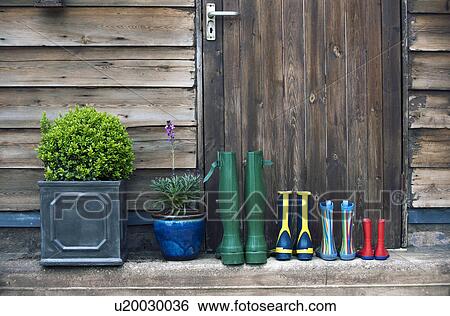 Stock Photograph - Rain boots and plants on porch. Fotosearch