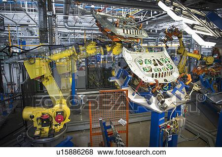 Stock Photo - Robots handling car parts in car factory. Fotosearch