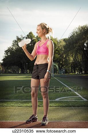Runner drinking water in park View Large Photo Image Stock Photography - Runner drinking water in park. Fotosearch