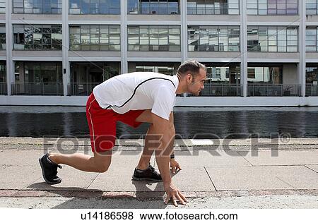Stock Photo - Runner poised on city street. Fotosearch